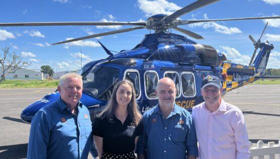 People standing in front of a helicopter